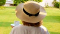 Senora female, age 50-55 in a straw hat holds a cup of hot drink and drinks coffee, sitting in the morning on a summer Royalty Free Stock Photo