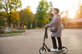 A senora in her 50s on a scooter in casual clothes enjoys life on a walk in the park. Active lifestyle in middle aged, sports.