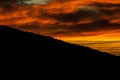 Sensational sunset behind the mountain with cloud formations Royalty Free Stock Photo