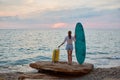 Sense of adventure, surfing, vacation time concept. Cute lady on summer trip posing on stone with surfboard. Copy space Royalty Free Stock Photo