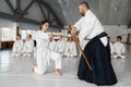 Sensei with young female student fighting with wooden sword