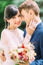 Sensitive close-up outdoor portrait of the smiling newlyweds. Royalty Free Stock Photo