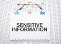 Sensitive Information text written on paper with pen and glasses Royalty Free Stock Photo