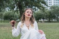 Sensitive portrait of an elegant girl in a park on the lawn