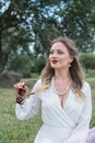 Sensitive portrait of an elegant girl in a park on the lawn