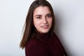 A sensitive pretty young girl with dark hair and brown eyes standing sideways having positive smile looking with happy expression. Royalty Free Stock Photo