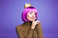 Sensitive stylish portrait fashionable joyful young woman celebrating carnival in golden crown on violet background