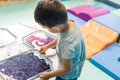 Sensory play for early brain development at nursery school. Toddler boy milk painting with his fingers, using nontoxic Royalty Free Stock Photo