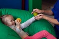 Sensory therapist massaging little girl patient with a little ribbed ball