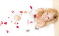 Sensual Alluring Caucasian Blond Female in Foamy Bathtub Filled with Flowery Petals During Skin and Body Treatment