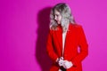 Sensual Alluring Caucasian Blond Female In Red Blazer Posing in Black Lingerie Against Pink Background