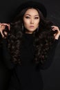 Sensual asian woman with long dark hair in black dress