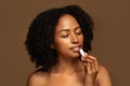 Sensual attractive half-naked young african american woman applying lipstick Royalty Free Stock Photo