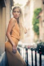 Sensual and attractive young blonde woman leaning against the wall on the street in the city. Royalty Free Stock Photo