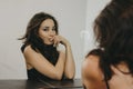 Sensual beautiful asian young woman with dark long hair looking at camera in front of mirror Royalty Free Stock Photo