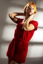 Sensual beautiful blonde woman posing in red dress. Girl with long curly hair. Royalty Free Stock Photo