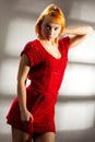 Sensual beautiful blonde woman posing in red dress. Girl with long curly hair. Royalty Free Stock Photo