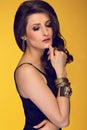 Sensual beautiful brunette woman posing in black dress and gold Royalty Free Stock Photo