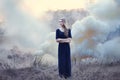 Sensual beautiful girl in smoke on natur