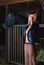Sensual blonde peasant girl in the stable with horse