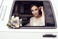 Sensual bride with dark hair in luxurious wedding dress posing in car Royalty Free Stock Photo