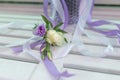 Sensual bright bouquet of fresh flowers with ribbons on the background of a white bench