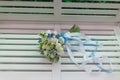 Sensual bright bouquet of fresh flowers with ribbons on the background of a white bench