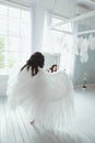 Sensual and beautiful young girl in bridal lingerie and angel wings looking in the mirror