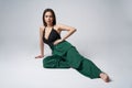 Sensual brunette female in green trousers and top with deep cleavage