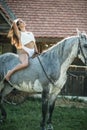 sensual brunette woman with sexy country look and horse. Portrait of a girl with brow lingerie and her horse Royalty Free Stock Photo