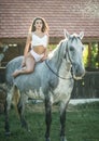 sensual brunette woman with sexy country look and horse. Portrait of a girl with brow lingerie and her horse Royalty Free Stock Photo