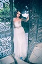 curly hair bride, opening a big ornamental metal doors and