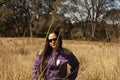 Sensual Caucasian Mexican woman with cool attitude looks out between golden spikes and plants in autumn atmosphere wearing Royalty Free Stock Photo