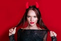 Sensual caucasian young woman with medium brunette hair in devil halloween costume Royalty Free Stock Photo