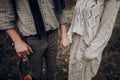 Sensual couple, gypsy woman in white boho dress holding hands wi