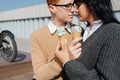 Sensual couple sitting outdoors, holding ice cream, kissing