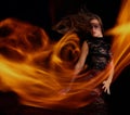 Sensual girl in black dress dancing with flame