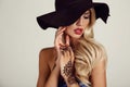Sensual girl in elegant black hat with mehendi pattern on hands Royalty Free Stock Photo