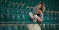 Sensual girl with long legs in the courts of a field .Long legs attractive blonde with curly hair relaxing on the chair Royalty Free Stock Photo