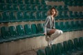 Sensual girl with long legs in the courts of a field .Long legs attractive blonde with curly hair relaxing on the chair Royalty Free Stock Photo