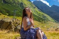 Sensual girl sitting against the high mountains background