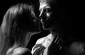 Sensual kiss. Romantic couple in love looking at each other, embracing and kissing on black background. Royalty Free Stock Photo