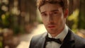 Sensual man posing in garden before wedding. Groom turning head right under arch