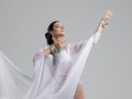 Sensual oriental belly dancer performance on gray studio background