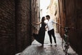 A sensual photo of two young people in a narrow street of the old city. Walk with a bike