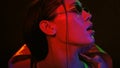 Sensual portrait of girl wearing down jacket and sunglasses in neon color lights . Pretty girl in neon light on black Royalty Free Stock Photo