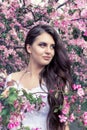 Sensual portrait of a spring woman, beautiful face, close up on blue eyes, female enjoying cherry blossom Royalty Free Stock Photo