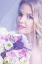 Sensual portrat of young beautiful bride holding flower bouquet