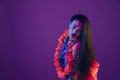 Attractive hawaiian brunette model on purple studio background in neon light