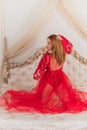 Sensual red hair woman in a red lace boudoir dress on a bed Royalty Free Stock Photo